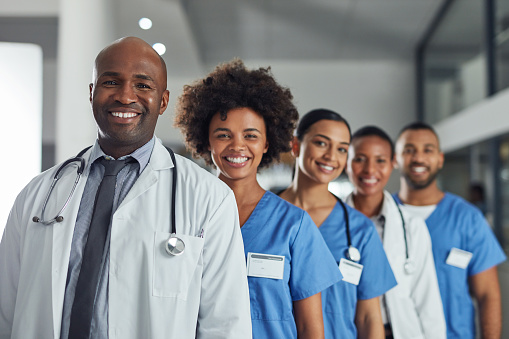 Portrait of a group of medical practitioners standing in a line in a hospital Portrait of a group of medical practitioners standing in a line in a hospital